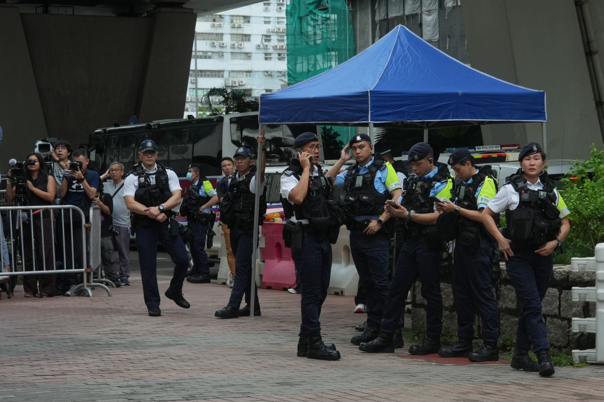 Hong Kong police arrest woman for seditious T-shirt outside court as democracy activists convicted